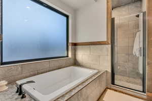 Full bathroom with a garden tub and a stall shower