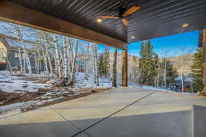 Snow covered patio with a ceiling fan and a patio
