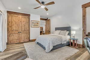 Bedroom with a closet, a ceiling fan, wood finished floors, and recessed lighting