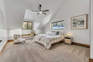 Bedroom with lofted ceiling, a ceiling fan, and light carpet