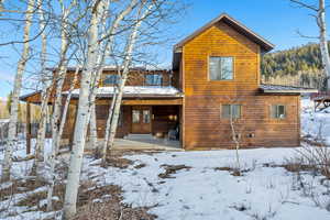 Snow covered house with a patio area and a metal roof