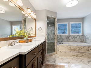 Full bath with a garden tub, double vanity, a marble finish shower, and light marble finish floors