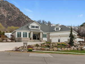 Craftsman house with covered porch, a garage, a shingled roof, and a mountain view