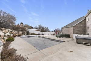 View of swimming pool featuring a fenced backyard, a hot tub, and a covered pool