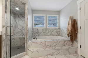 Bathroom featuring marble look tile flooring, a marble finish shower, and a bath