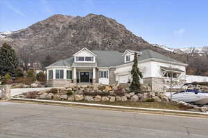 View of front facade featuring covered porch, a mountain view, a garage, and brick siding