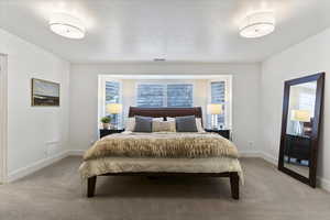 Bedroom featuring carpet and baseboards