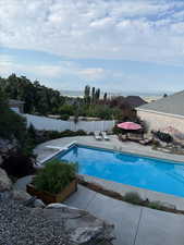 View of pool featuring a patio, a diving board, and a fenced backyard