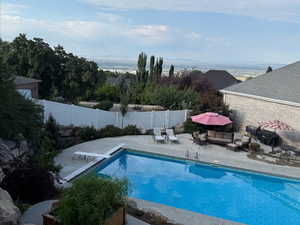 View of pool featuring a patio, a diving board, and a fenced backyard