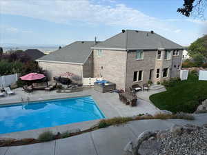 View of pool with a patio area, a fenced backyard, outdoor lounge area, and a gate