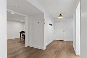 Hallway with light wood-type flooring and baseboards