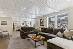 Living area with wood finished floors, recessed lighting, and a wooden ceiling with exposed beams