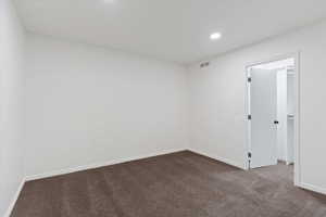 Unfurnished room featuring dark carpet and recessed lighting