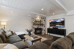 Living room featuring wood finished floors, a fireplace, a wooden ceiling with exposed beams, and recessed lighting