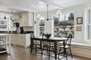 Dining room with a wooden ceiling with exposed beams and light wood-type flooring