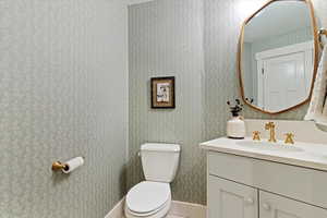 Bathroom with vanity and wallpapered walls