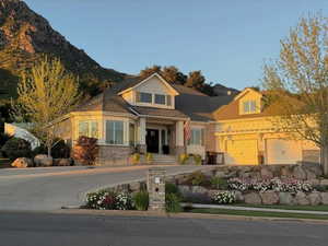 View of front of house featuring covered porch, an attached garage, and stone siding