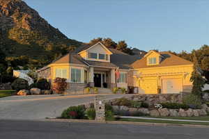 View of front of home featuring concrete driveway and stone siding