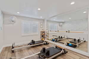 Workout area with light wood-type flooring, recessed lighting, and a textured ceiling