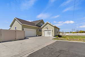 View of front of home featuring a garage, concrete driveway, and a gate