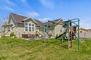 Back of property with a lawn, a patio area, and a playground
