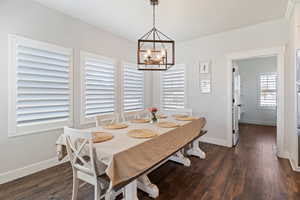 Dining area featuring dark wood finished floors and a chandelier