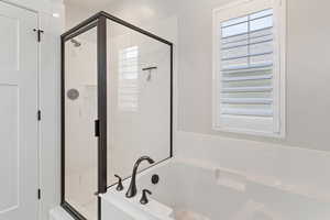 Full bathroom featuring a shower stall and a bath