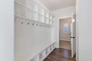 Mudroom with dark wood-style floors and baseboards