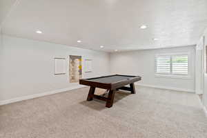 Game room featuring light colored carpet, pool table, recessed lighting, and a textured ceiling