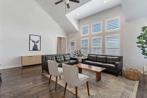 Living room with a high ceiling, wood finished floors, ceiling fan, and recessed lighting
