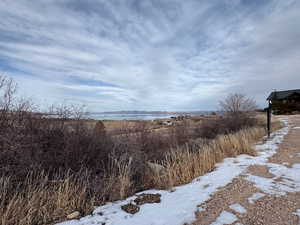 Yard layered in snow with a water view