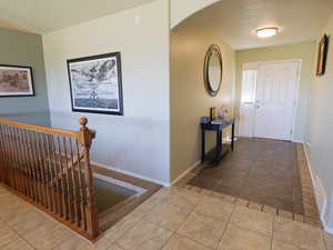 Tiled foyer entrance featuring arched walkways and a textured ceiling