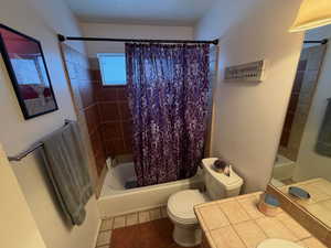 Bathroom with shower / tub combo with curtain, vanity, and tile patterned floors