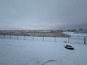 Yard layered in snow featuring a view of countryside