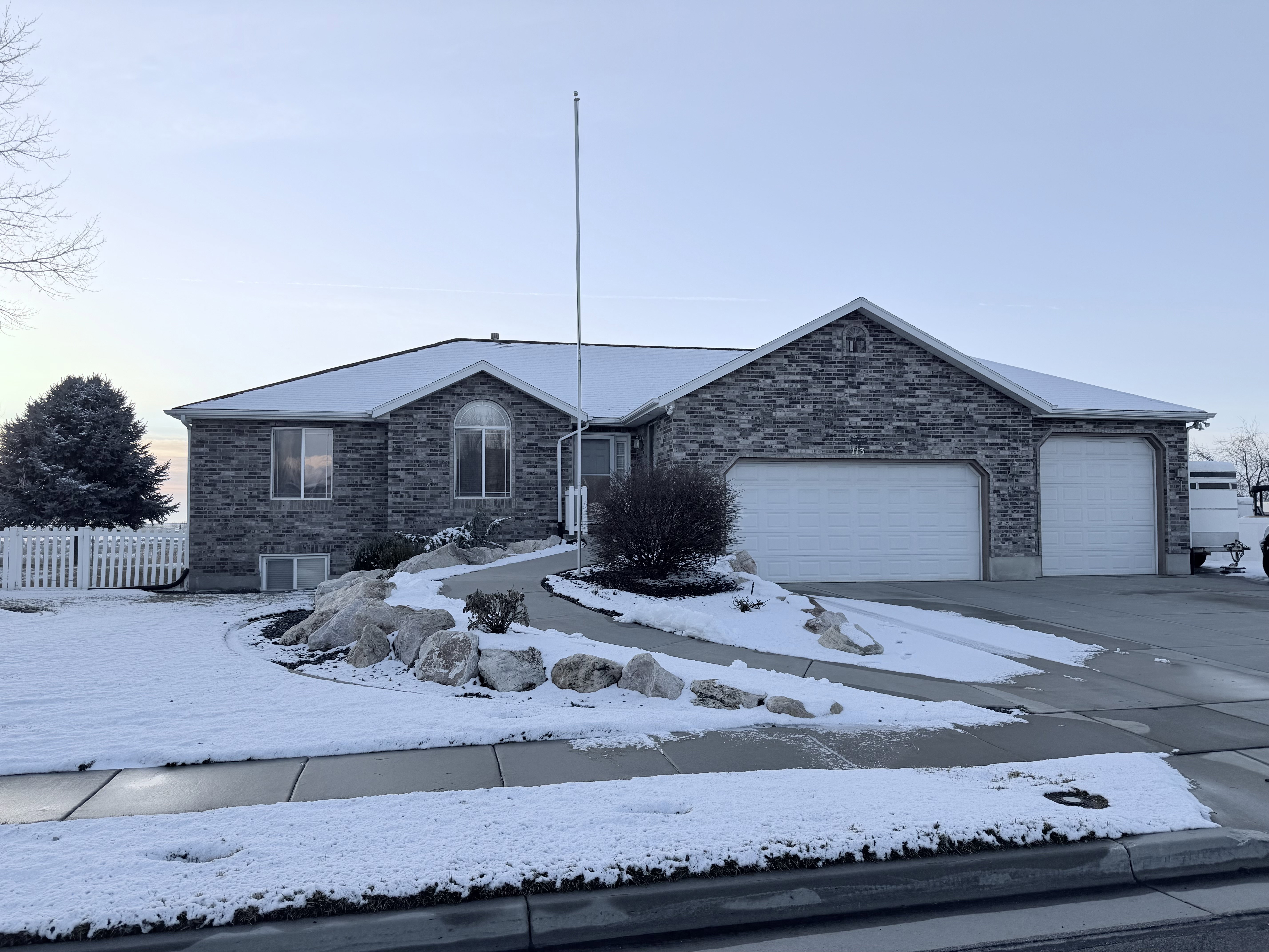 Ranch-style home featuring brick siding, an attached garage, and driveway