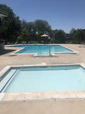 Community pool and hot tub with a patio area