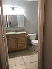 Half bathroom with vanity and light tile patterned floors