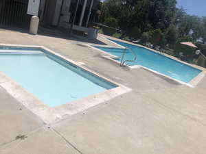 Community hot tub and pool featuring a patio area