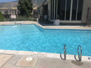 Community pool with a community hot tub, a mountain view, and a patio area