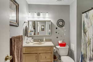 Bathroom with a shower with curtain, vanity, and a textured ceiling