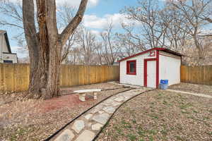Fenced backyard with an outbuilding