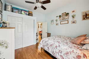 Bedroom with a closet, wood finished floors, and ceiling fan