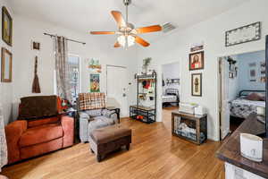 Living room with light wood finished floors and a ceiling fan
