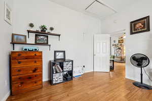 Living area with attic access and wood finished floors