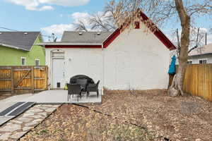 Back of property with a patio, a fenced backyard, a gate, brick siding, and a shingled roof