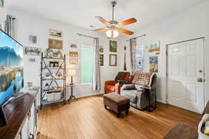 Living area with light wood-type flooring and a ceiling fan