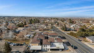 Aerial view of property and surrounding area with nearby suburban area