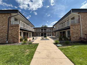 View of community with a lawn, a balcony, and a patio
