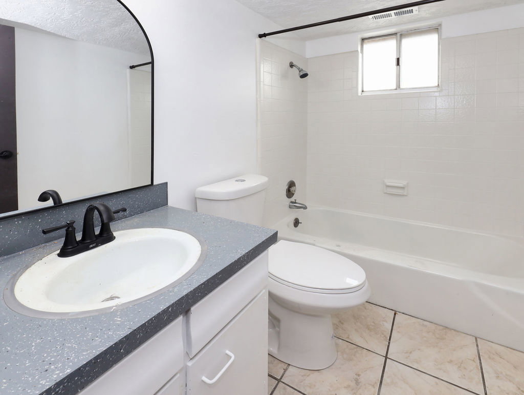 Unit #1- Bathroom featuring shower / bathtub combination, vanity, and a textured ceiling