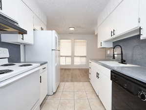 Unit #1- Kitchen featuring white range with electric cooktop, white cabinets, dishwasher, a textured ceiling, and light tile patterned flooring